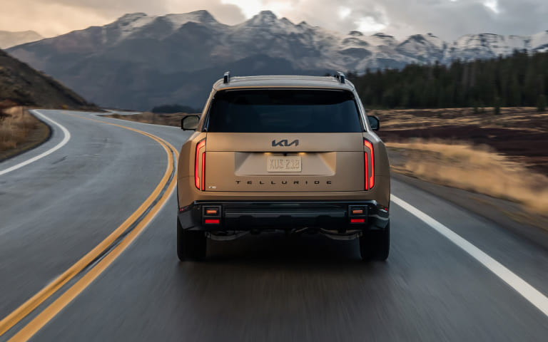Customer near a Kia vehicle while reviewing leased Kia sale and trade options