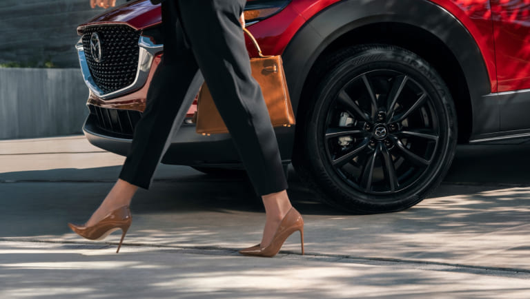 Driver stepping out of a Mazda SUV before selling or trading a vehicle