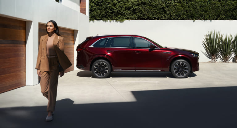 Customer walking near a red Mazda SUV before reviewing lease-end options